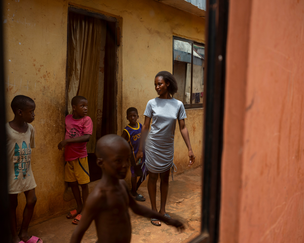 NIGERIA. Anambra. September 9, 2024. View of Theresa's home. Theresa, a survivor of sex trafficking in Anambra, was rescued from Dubai and returned to Nigeria with the help of an NGO. She had a life of abuse and violence, often beaten for refusing to engage in sexual acts. Her life has been marked by struggle from the very beginning. Born a twin, her brother tragically died just days after birth. Facing pressure to sacrifice Theresa, her father abandoned her in a bush, but her mother intervened and placed her in the care of an aunt. At the age of 12, Theresa confronted her father and declared her determination to become stronger than him, he accepted her back into the family before leaving to fight Boko Haram as a soldier. Following his death, Theresa has taken on the responsibility of being the family’s sole breadwinner.